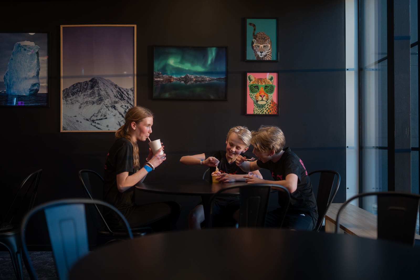 Drei Kinder mit Slush und Eis an einem Tisch in der Eisbar.
